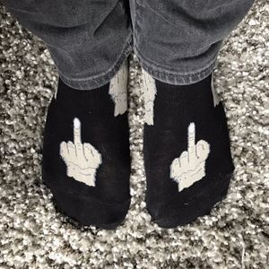 Feet wearing socks with middle fingers embroidered on them.