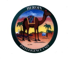 The Heroin Intelligence Unit patch shows a camel in the desert wearing a fez. Its hump is covered with some fabric with a poppy plant pattern.