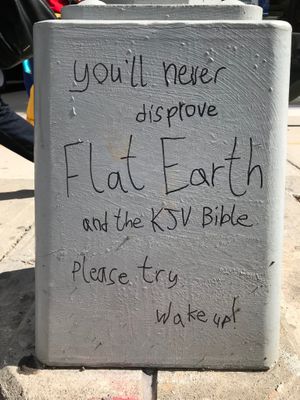 Written on the base of a light pole: “You’ll never disprove Flat Earth and the KJV Bible. Please try. Wake up!”