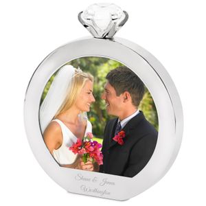 A wedding photo in a round picture frame shaped like a diamond ring